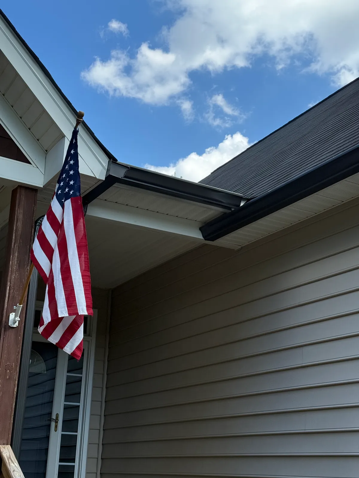 Black gutters on a gray vinyl home over the front porch in the Charlotte, NC area