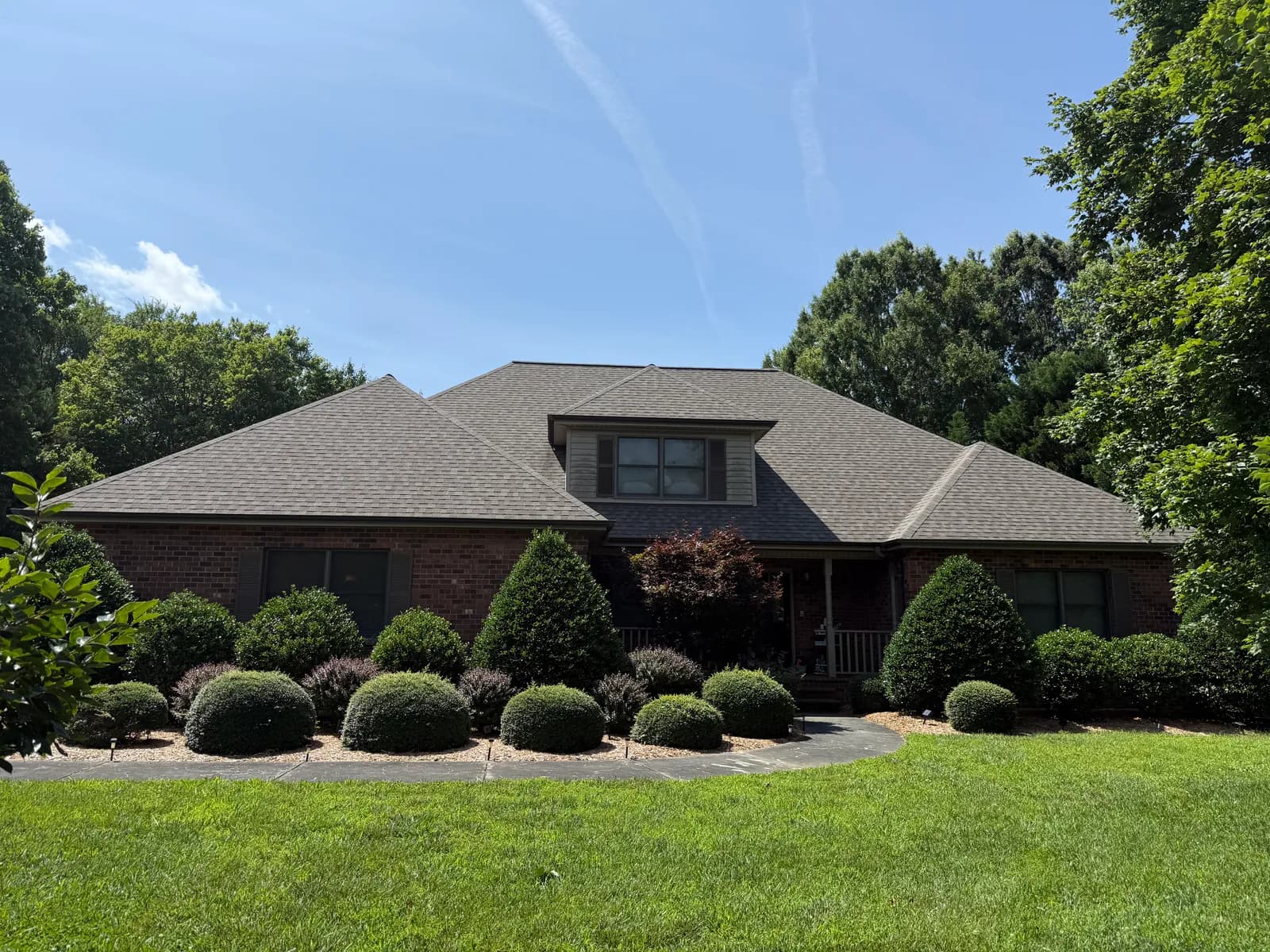 Brick ranch with dark bronze seamless gutters on a wooded lot in the Charlotte, NC area