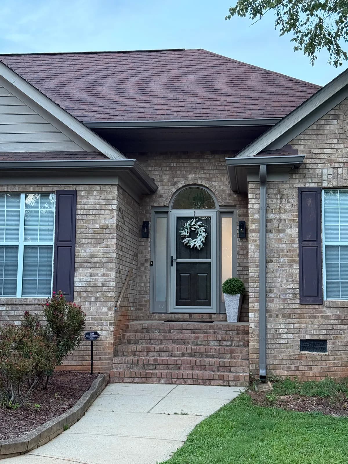 Brick ranch with gray seamless gutters and a new downspout by the front steps, Charlotte, NC area